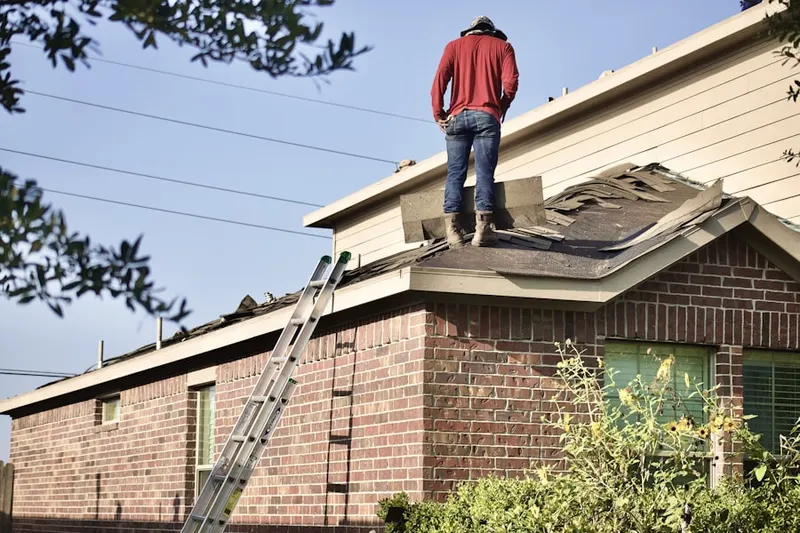 Professional roofer working on a residential roof in North Prairie Lee